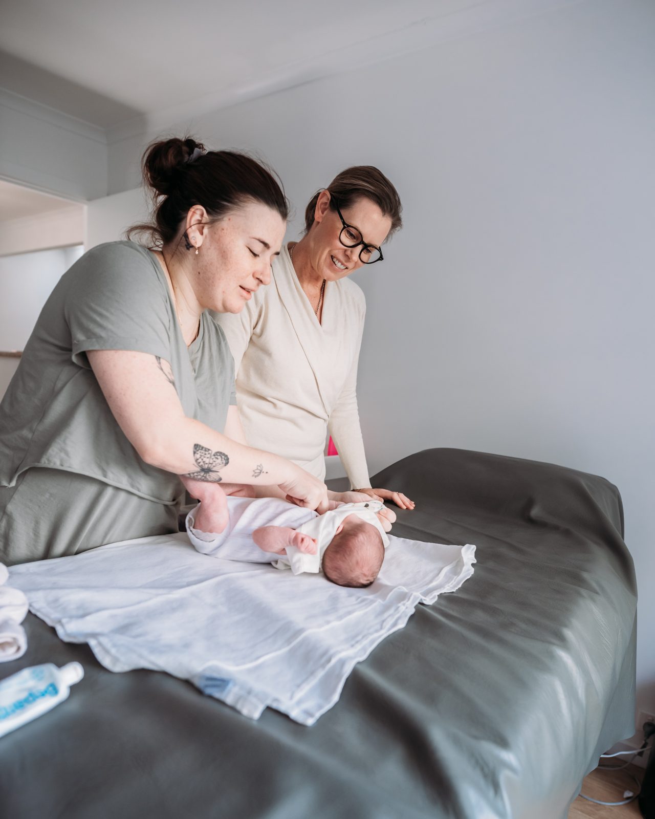 Penny helping a mother dress her newborn at home