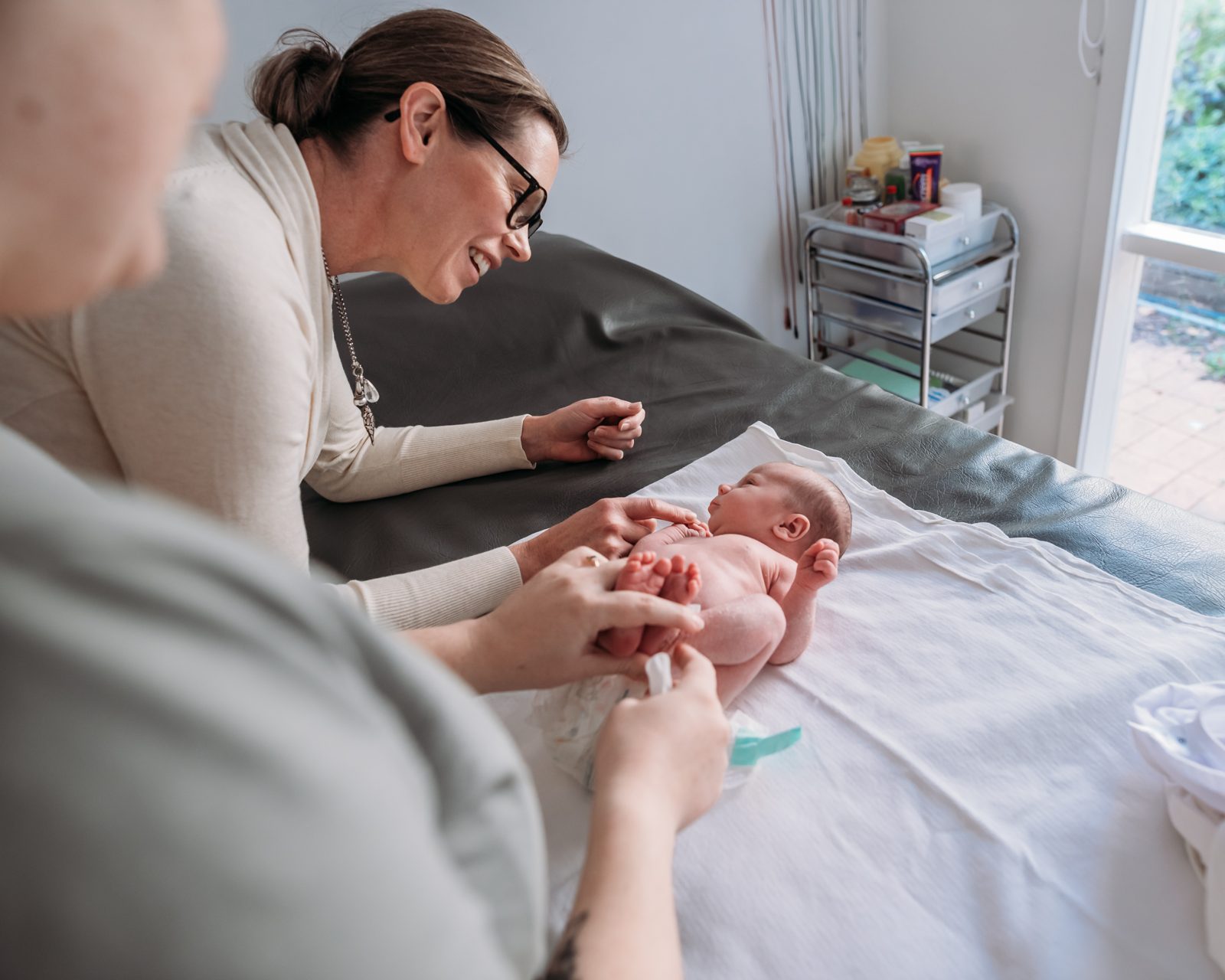Penny checking a newborn with her mother
